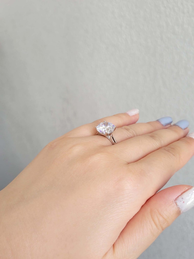 May include: A silver ring with a large, clear, round-cut gemstone.
