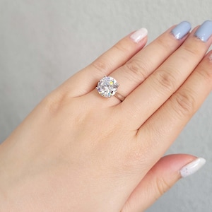 May include: A silver ring with a large, clear oval-shaped gemstone.