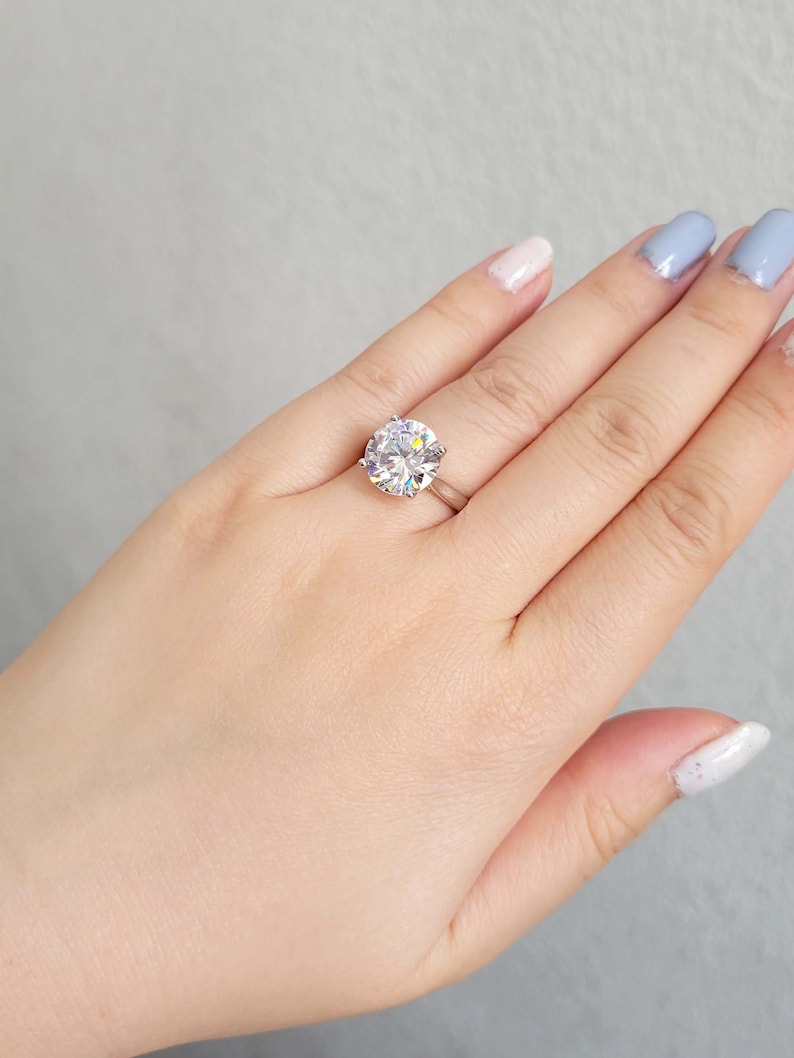 May include: A silver ring with a large, clear oval-shaped gemstone.