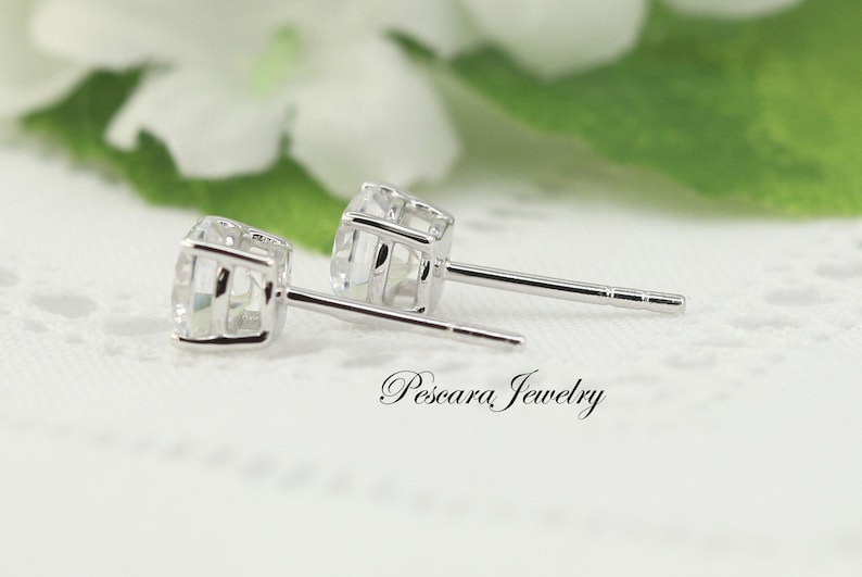 May include: A pair of silver stud earrings featuring clear cubic zirconia stones. The earrings have a simple, elegant design and are ideal for everyday wear.