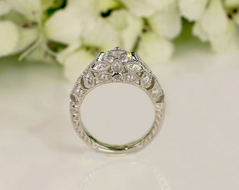 Puede incluir: Un anillo de compromiso de plata con una piedra central grande y transparente y piedras más pequeñas engastadas en un delicado diseño floral.