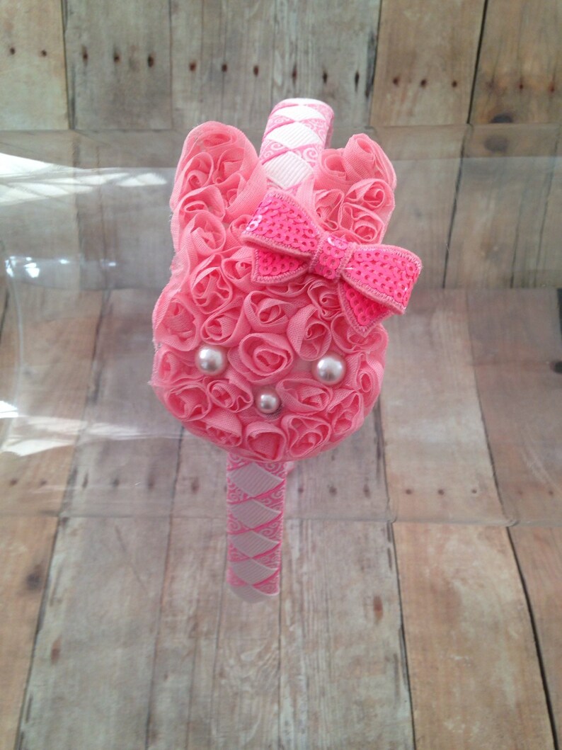 Puede incluir: Diadema rosa con un dise&ntilde;o de conejo 3D. El conejo est&aacute; hecho de tela rosa y tiene un lazo rosa con lentejuelas. La diadema est&aacute; decorada con una cinta blanca y rosa.