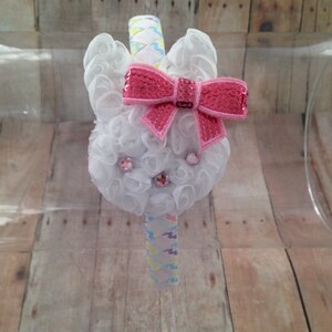 Puede incluir: Diadema de conejito blanco con un lazo rosa de lentejuelas y pedrer&iacute;a. La diadema est&aacute; decorada con una cinta de colores.