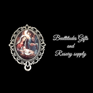 May include: Silver-toned oval-shaped pendant with a detailed ornate design. The pendant features a colorful image of the Holy Family, Mary, Joseph, and baby Jesus. The pendant is attached to a silver-toned bail.