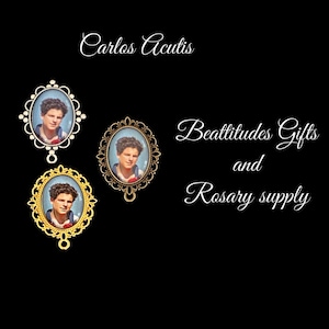 May include: Two silver and gold oval-shaped medallions with a picture of Carlos Acutis. The medallions have a decorative border and a loop for hanging. The text "Beatitudes Gifts and Rosary supply" is written in cursive below the medallions.