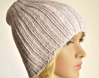 May include: A light pink knitted beanie hat with a ribbed texture.