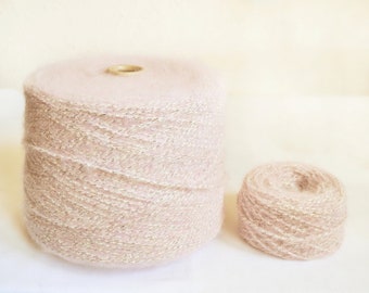 May include: Two spools of pink yarn with a subtle shimmer. The larger spool is full, while the smaller spool is partially wound.