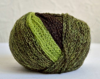 May include: A ball of yarn with green, brown, and dark green stripes. The yarn is soft and fluffy.