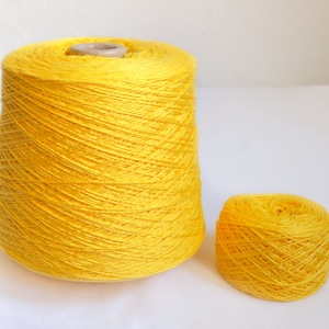 Peut inclure: Une grande bobine de fil jaune vif et une petite pelote du même fil.