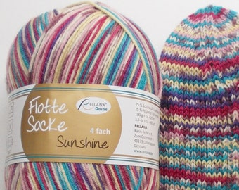 May include: A ball of colorful yarn with a label that reads "Flotte Socke Sunshine 4 fach" and a knitted sock made from the yarn. The yarn is a mix of pink, red, yellow, blue, and purple.
