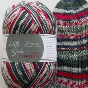 以下が含まれることがあります： 赤、白、緑、青の糸の玉で、「Flotte Socke 4 FACH CHRISTMAS ELLANA Garne」と書かれたラベルが付いています。糸は同じ色の模様の編まれた靴下と並んでいます。