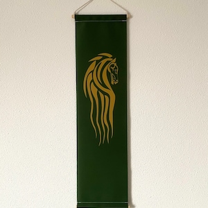 以下が含まれることがあります： 金の馬の頭のデザインが施された緑色のバナー。馬の頭はスタイリッシュで、流れるようなたてがみがあります。