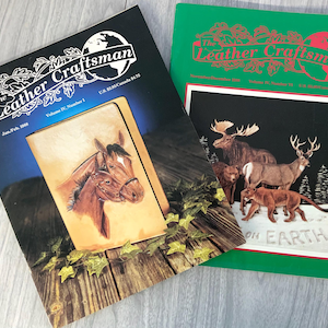 May include: Two copies of The Leather Craftsman magazine. The front cover of the first magazine features a horse and foal carved in leather. The front cover of the second magazine features a moose, deer, and cougar carved in leather. Both magazines have a green background with a globe and the title "The Leather Craftsman" in red.
