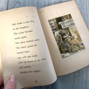 K&ouml;nnte beinhalten: Offenes Vintage-Kinderbuch mit Text und Illustration. Der Text lautet: &bdquo;Owl made a new fire in the fireplace.&ldquo; Die Illustration zeigt eine Eule in einem Stuhl in der N&auml;he eines Kamins. Die Seiten des Buches sind gealtert und haben einen hellbraunen Farbton.
