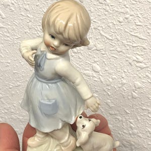 vintage ceramic girl with dog tugging on her dress figurine, small girl and puppy, puppy figurine, girl in dress figurine, glossy ceramic