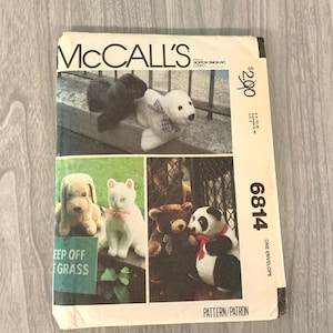 May include: A vintage McCall's sewing pattern envelope featuring images of stuffed animal toys. The toys include a black bear, polar bear, dog, cat, teddy bear, and panda bear. The envelope has the text "McCall's" and "Keep Off Grass".