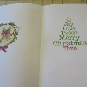 May include: A white card with a green Christmas tree design. The tree is made of words, starting with a star at the top and reading "Joy, Love, Peace, Merry Christmas, Time". The card also has a green wreath with two gold bells and a red bow on the left side.