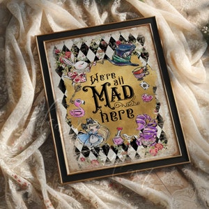 May include: A gold and black framed print with a whimsical illustration of Alice in Wonderland characters. The print features a black and white checkered background with a gold inscription that reads "We're all Mad here."