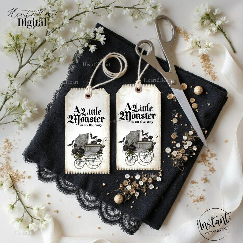 May include: Two rectangular paper tags with a vintage cream background, each featuring the black text A little Monster is on the way and an illustration of a baby carriage with bats. Each tag has a white string loop at the top for hanging.