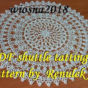 Op de afbeelding: Een wit gehaakt doily met een delicaat patroon. De doily is rond en heeft een centrale cirkel met een spiraalvormig ontwerp. De tekst "PDF shuttle tatting pattern by Renulek" staat in gele letters op de doily.