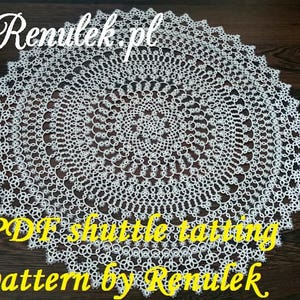 May include: White crochet doily with a circular design. The doily is on a wooden surface. The text "PDF shuttle tatting pattern by Renulek" is written in yellow letters on the bottom of the image.