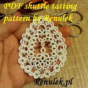 May include: White crocheted doily with a delicate pattern. The doily is held in a hand and the text "PDF shuttle tatting pattern by Renulek" is visible above the doily. The text "Renulek.pl" is visible below the doily.