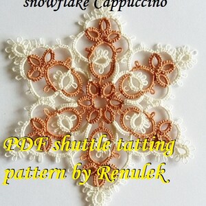 May include: A white and brown snowflake pattern made with shuttle tatting. The pattern is called "Snowflake Cappuccino" and is by Renulek. The pattern is available as a PDF download.