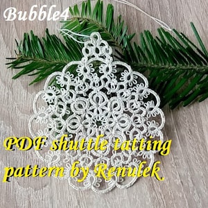 May include: White crocheted snowflake ornament with a delicate pattern. The ornament is hanging from a white string and is surrounded by green pine branches. The text "PDF shuttle tatting pattern by Remulek" is written in yellow letters below the ornament.