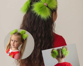 May include: A pair of bright lime green faux fur hair accessories shaped like pom-poms, each featuring a small center band with red and white stripes. These fuzzy hair ties are shown worn in pigtails and space buns by individuals with long hair.