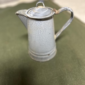 May include: A vintage gray enamel coffee pot with a lid and a handle. The pot has a speckled finish and a slightly worn look.