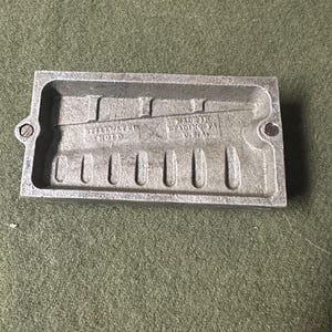 May include: A gray metal mold with six rectangular cavities and the text "MADE IN READING PA. U.S.A." on the bottom.