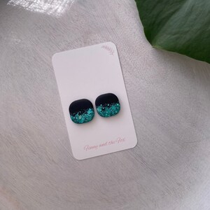 Square matte black studs with teal green glitter. Resin earrings.