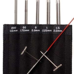 May include: A set of 10 double-pointed knitting needles in a black case. The needles are made of stainless steel and come in sizes 000 (1.5 mm), 00 (1.75 mm), 0 (2.0 mm), 1 (2.25 mm), and 1.5 (2.5 mm).