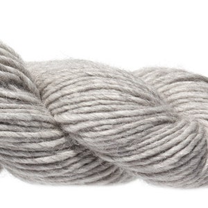 Puede incluir: Un ovillo de hilo gris claro, hecho de una mezcla de lana y alpaca.