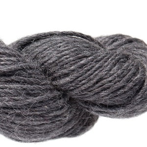 Puede incluir: Un ovillo de hilo gris oscuro, perfecto para tejer o hacer ganchillo.