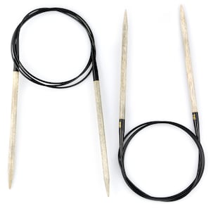 May include: A set of two knitting needles, one with a circular cable and one with a straight needle. The needles are made of wood and have black tips. The needles are 25.4 cm long.