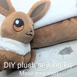 May include: A brown plush toy with large ears, a white collar, and black eyes. The text "DIY plush sewing kit Make your own plushie!" is visible. Sewing patterns and white fabric are also in the image.
