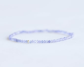 Delicato bracciale elastico in tanzanite, delicato gioiello con piccole perle sfaccettate e pietra portafortuna di dicembre