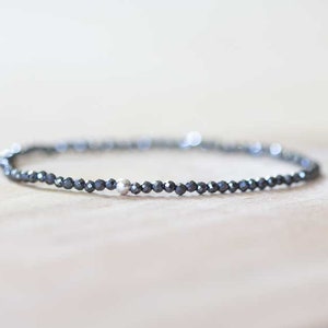 Delicato bracciale elastico in ematite, gioiello con piccole perline sfaccettate e pietre preziose nere, bracciale elastico