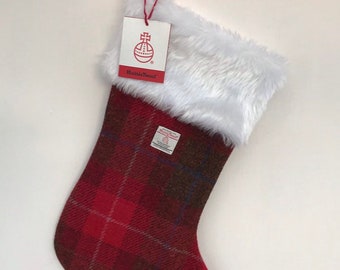 Könnte beinhalten: Roter und brauner karierter Weihnachtsstrumpf mit weißem Kunstfellbesatz. Der Strumpf hat eine Schlaufe oben zum Aufhängen und ein Etikett mit der Aufschrift "Harris Tweed".