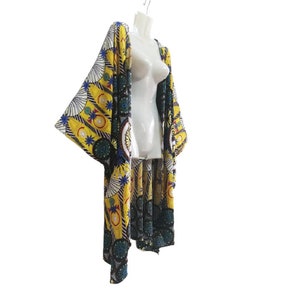 May include: A yellow and blue patterned kimono with a long, flowing design. The kimono has a wide, open collar and long sleeves.