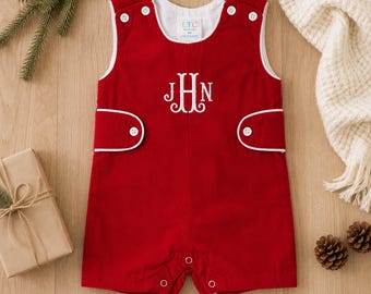 May include: A sleeveless red romper featuring white piping trim, white buttons at the shoulders and sides, and a white embroidered monogram with the letters JHN on the chest. The garment includes a white inner lining and a label reading LTC 6M.