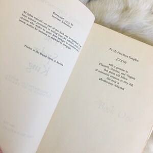 May include: A book titled "Judith" with the text "Copyright, 1954, by Lawrence Schoonover" and "Printed in the United States of America". The book is dedicated to the author's first-born daughter.