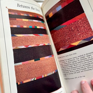 May include: A book page with a colorful woven rug design and text that reads "Between the lines" and "Materials Berber yarns; linen warp." The text describes the construction of the rug, which is inspired by Navajo Indian designs.