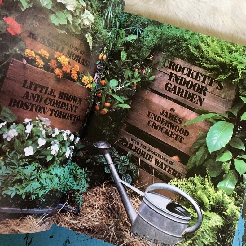 Puede incluir: Un libro titulado "Crockett's Indoor Garden" de James Underwood Crockett con la ayuda de Marjorie Waters. La portada del libro presenta un jard&iacute;n interior exuberante con una regadera.