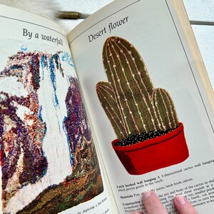 May include: A latch hook wall hanging depicting a cactus in a red pot. The cactus is green with brown stripes and is three-dimensional. The text "Desert flower" is at the top of the image.