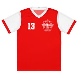 May include: A red and white soccer jersey with the number 13 on the front. The jersey has a V-neck and white sleeves. A crest with the word "PERSEPOLIS" is on the right side of the chest.