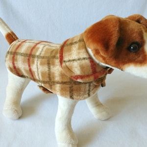 May include: A brown and tan plaid dog coat with red accents. The coat is made of soft fleece and has a collar.