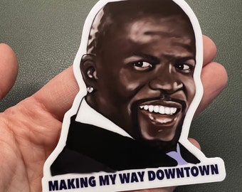 May include: A white sticker with a black and white illustration of a man with a big smile. The text "MAKING MY WAY DOWNTOWN" is printed in blue at the bottom of the sticker.