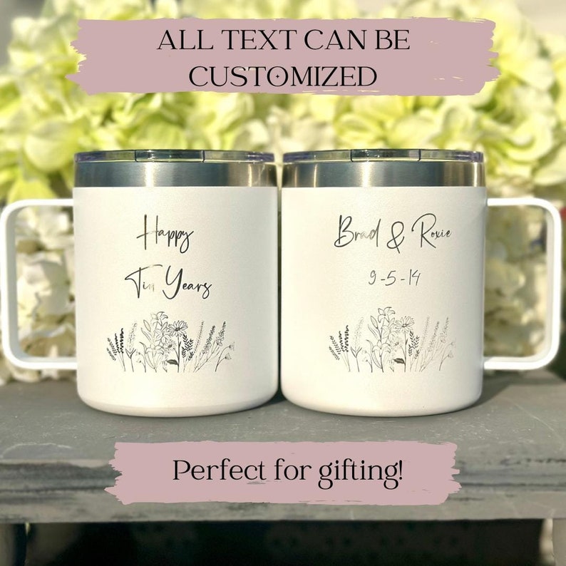 Two white mugs with wildflower engravings. Left mug reads "Happy Ten Years," right mug reads "Brad & Rosie 9-5-14.